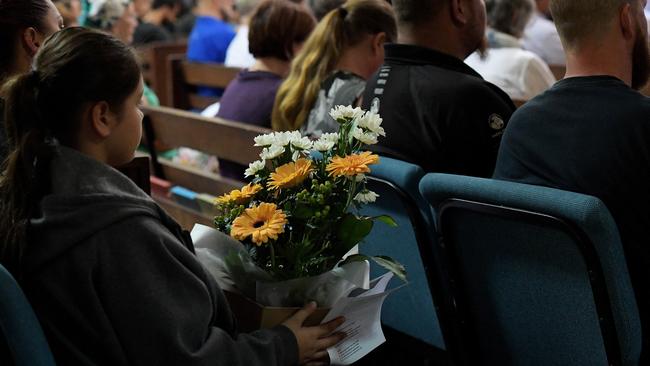 A mourner holds flowers at a vigil held at Darwin Uniting Church to mourn the shooting deaths of Hassan Baydoun, Nigel Hellings, Rob Courtney and Michael Sisois on June 6. Picture: Keri Megelus
