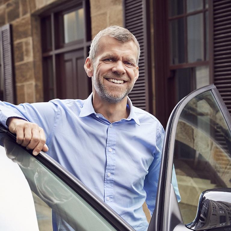 Ola Australia and New Zealand managing director Simon Smith with one of the company's rideshare vehicles.