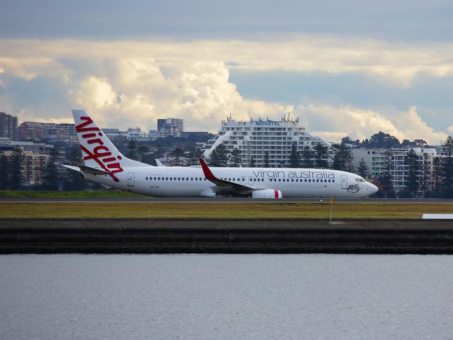 SYDNEY, AUSTRALIA - NewsWire Photos JUNE 14, 2021: A view of a Virgin plane landing at Sydney Domestic Airport from Port Botany in Sydney Australia. Picture: NCA NewsWire / Gaye Gerard