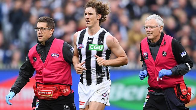 Chris Mayne is helped from the ground by trainers during Saturday’s win over Geelong. Picture: Quinn Rooney/Getty Images. 