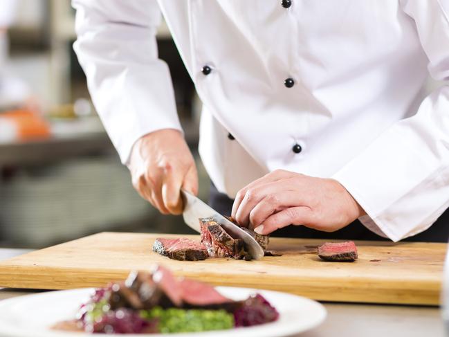 Chef in restaurant kitchen preparing food