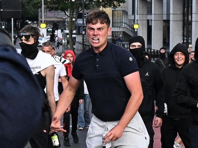 Riot police face protestors in Bristol, southern England, on August 3, 2024 during the 'Enough is Enough' demonstration held in reaction to the fatal stabbings in Southport on July 29. UK police prepared for planned far-right protests and other demonstrations this weekend, after two nights of unrest in several English towns and cities following a mass stabbing that killed three young girls. (Photo by JUSTIN TALLIS / AFP)