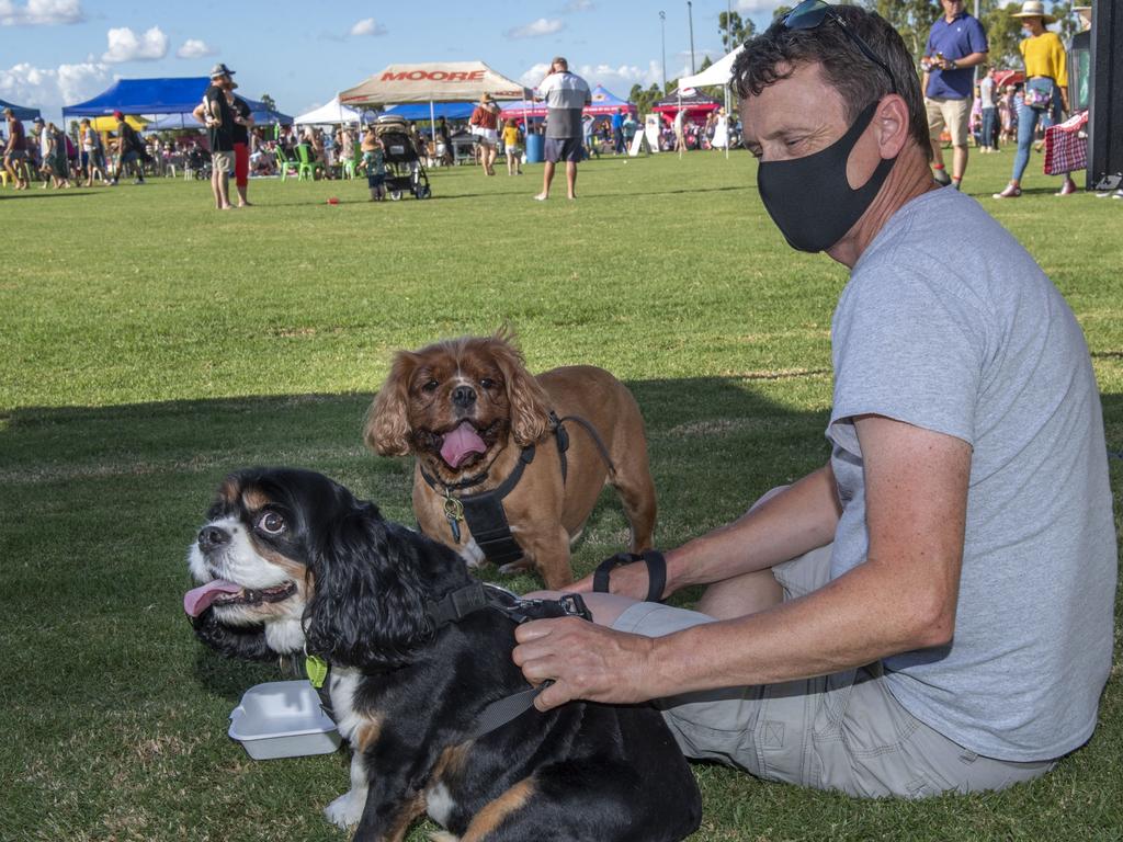 Adrian Poyton and king charles cavalier dogs Buddy and Oakley hydrate on a warm day at the Toowoomba Street Food Festival at Pittsworth. Saturday, January 29, 2022. Picture: Nev Madsen.