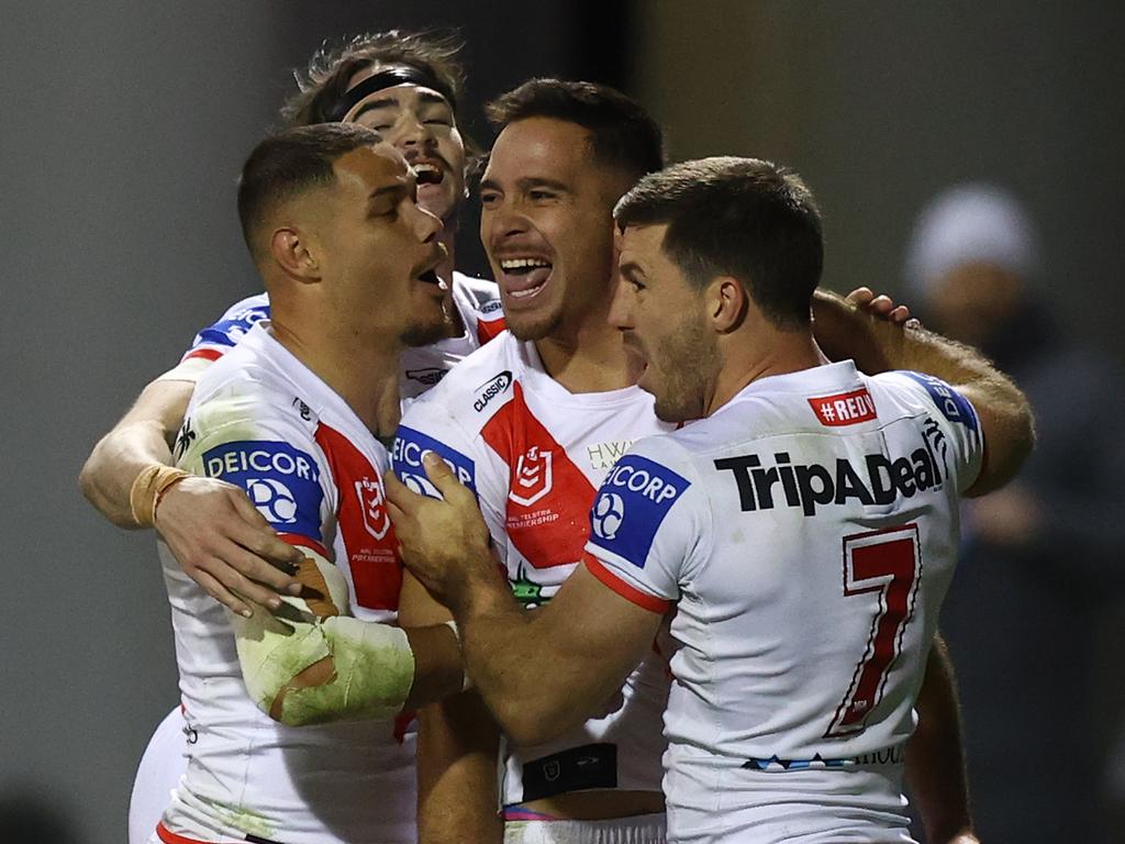 Corey Norman celebrates scoring a try with some Dragons teammates.