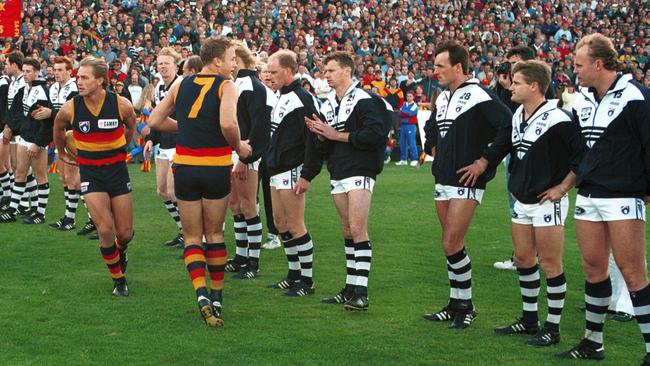 Geelong footballers standing in line as Adelaide Crows players make their way onto the ground in 1994.