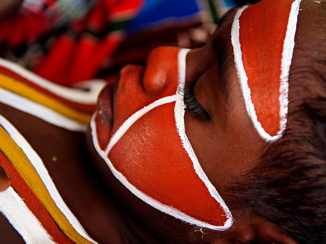 Dhunumbu Munuggurr being painted by grandmother Bawuli Marika for the Rirratjingu welcoming ceremony with a Rirratjingu clan design (minytji) depicting the wirrkul ( Wagilak sisters who traveled with Wuyal the Sugar Bag ancestor) pattern on his face and Gulwirri (palm) design on his chest. Picture: Michael Franchi