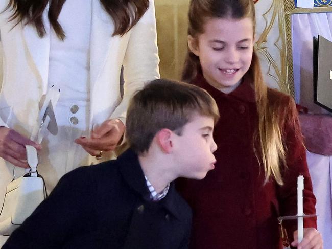 Britain's Princess Charlotte of Wales (R) has her candle blown out by Britain's Prince Louis of Wales (L) at the 