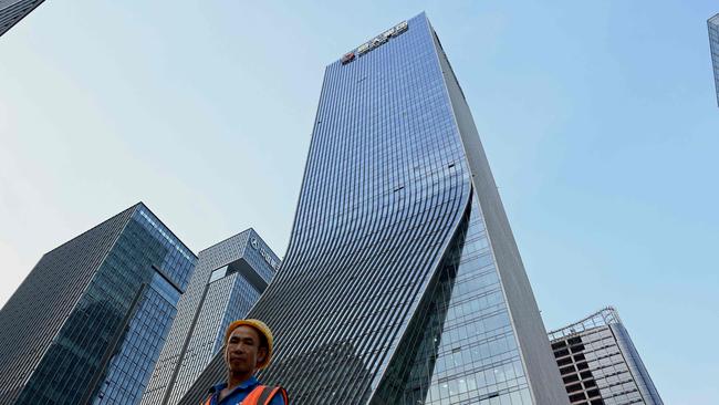 A worker walks in front of the Evergrande headquarters in Shenzhen, China's southern Guangdong province. Picture: AFP