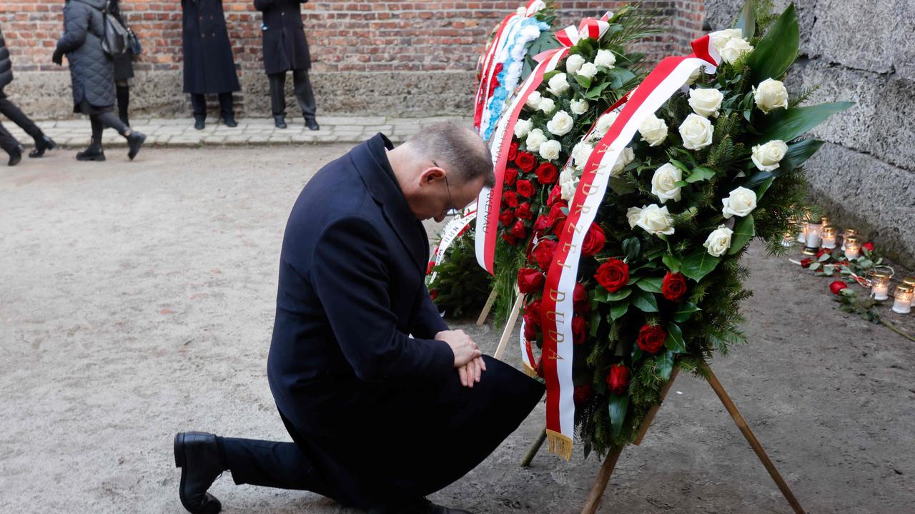 Polish President Andrzej Duda kneels in front of wreaths. Picture: AFP