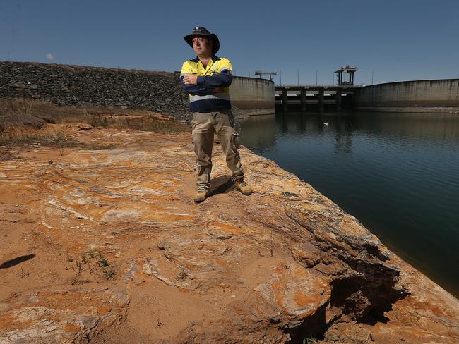 24/10/2019: Senior dam operator Matthew O'Reilly stands in an area that should be covered in meters of water if Wivenhoe Dam were full, instead of being at about half its capacity because of on going drought, Wivenhoe dam, west of Brisbane. Lyndon Mechielsen/The Australian