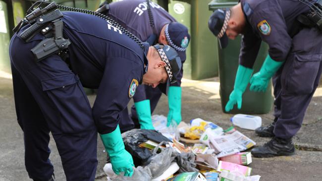 Police look through garbage after the alleged murder of Peter Hofmann.
