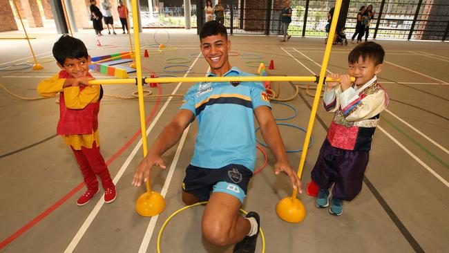 Members of the Titans coming to meet kids and parents at St Joseph's College Pimpama. Titans youth member Alofiana Khan Pereira has the bar set by five year old students Shriyansh Bodhanapally and Siwoo Kim. Picture Glenn Hampson