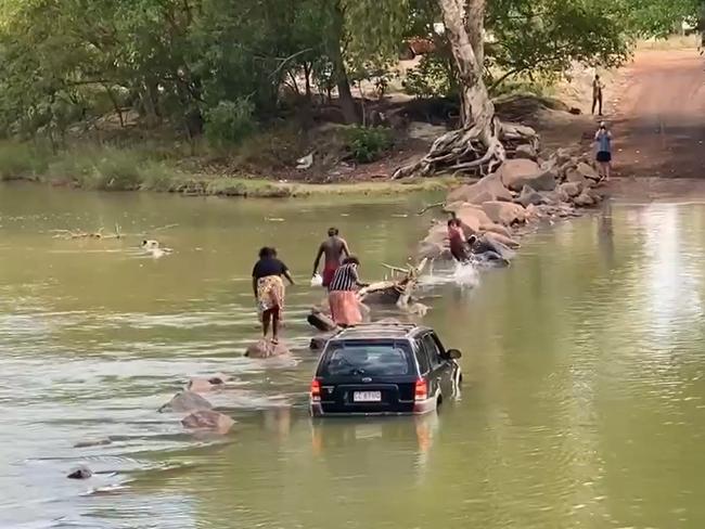 NAIL-BITING VIDEO: Man falls into croc-infested Cahills Crossing after group floods car