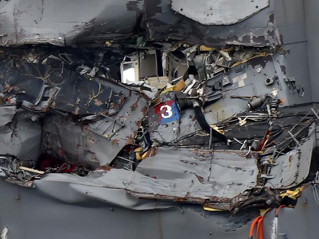 Damage to the guided missile destroyer USS Fitzgerald is seen as the vessel is berthed at its mother port in Yokosuka, southwest of Tokyo, on June 18, 2017.  The bodies of US sailors missing after their destroyer collided with a container ship off Japan have been found in flooded sleeping berths, a day after the accident tore a huge gash in the warship's side, the US Navy said on June 18. / AFP PHOTO / Kazuhiro NOGI