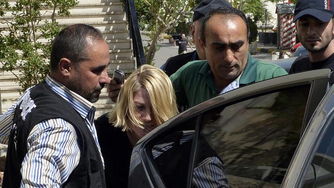 Brown is bundled into a car after her court appearance.