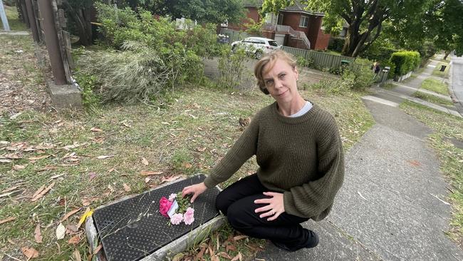 Sharon Arens lays flowers at the scene of a collision where a 17-year-old boy died at Rembrandt St, Carlingford.