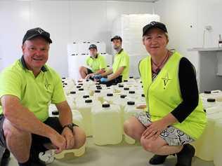 HELPING OUT: Ian Henderson and Josie Howard and (back) vinegar makers Michael Britten and Joerg Achenbach with just some of the bottles sent to Townsville. Picture: Liana Walker