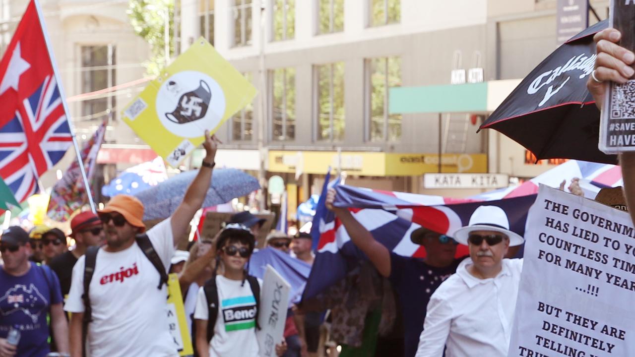 A Melbourne protester with a sign of a swastika on a mask. Photo: NCA NewsWire / David Crosling