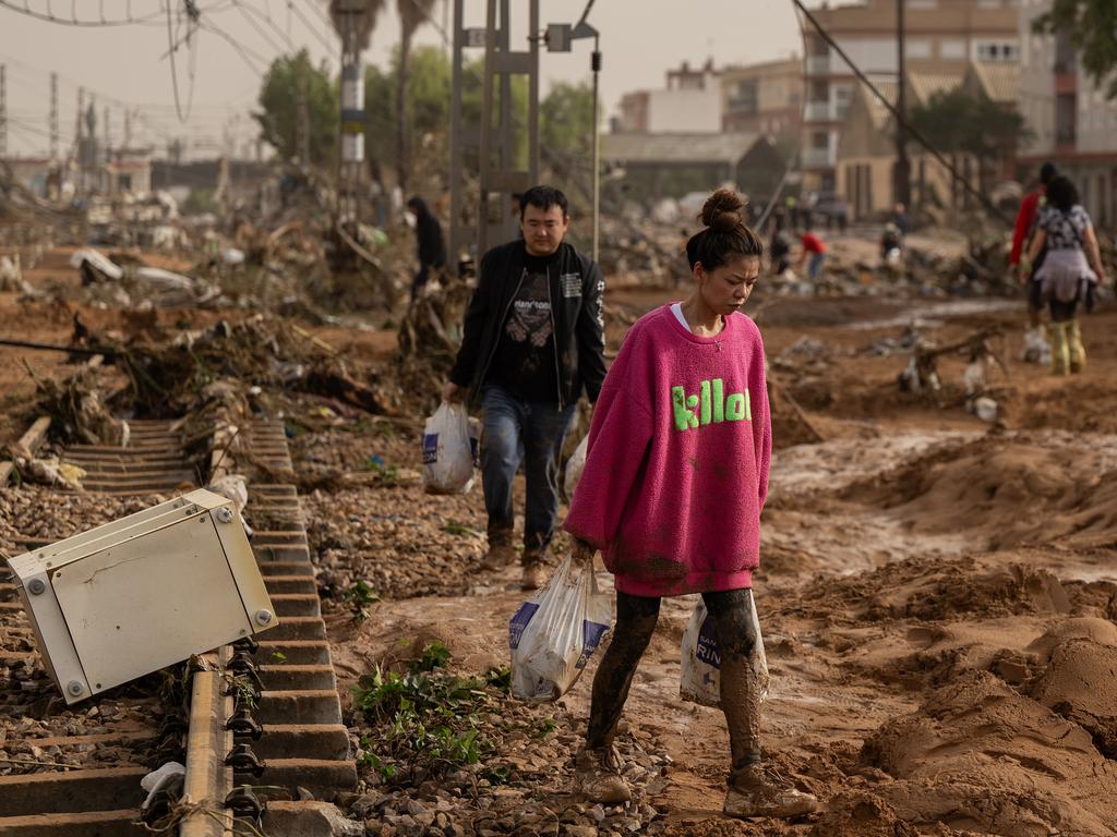 A woman walks along train tracks covered debris in Valencia. Picture: David Ramos/Getty Images