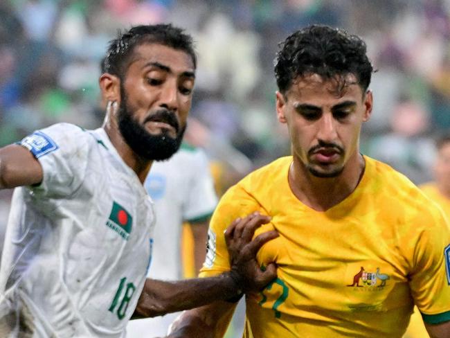 Australia's Daniel Arzani (R) fights for the ball with Bangladesh's Isa Faysal during the 2026 FIFA World Cup Asian qualification football match between Bangladesh and Australia at the Bashundhara Kings Arena in Dhaka on June 6, 2024. (Photo by MUNIR UZ ZAMAN / AFP)