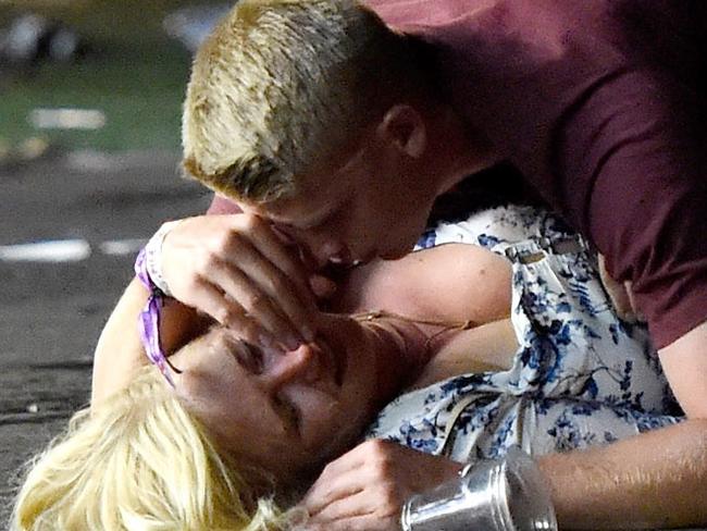 A man lays on top of a woman as others flee the Route 91 Harvest country music festival grounds after a active shooter was reported on October 1, 2017 in Las Vegas, Nevada. A gunman has opened fire on a music festival in Las Vegas, leaving at least 2 people dead. Police have confirmed that one suspect has been shot. The investigation is ongoing. The photographer witnessed the man help the woman up and they walked away. Injuries are unknown.  Picture: Getty Images