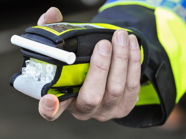 Belfast, Northern Ireland. 24 Nov 2016 - A police officer holds a roadside breathalyser alcohol breath test after taking a sample from a driver.