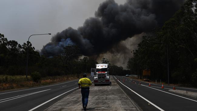 A truck driver prepares to move his vehicle through a roadblock bypass on the Princes Highway near the town of Sussex Inlet. Picture: Sam Mooy/Getty