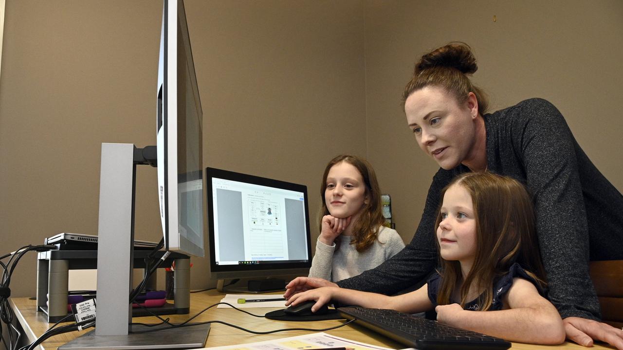 Sisters Paige Lake (left) Grade 4 and Amber Lake , grade 2 study at home with their mum Merissa Lake . The girls are students at Highfields State School. Photo Bev Lacey