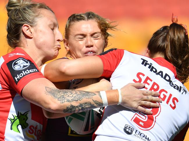 Julia Robinson (centre) of the Broncos is tackled by Holli Wheeler (left) and Jessica Sergis (right) in the NRL Women's Premiership match on Sunday.