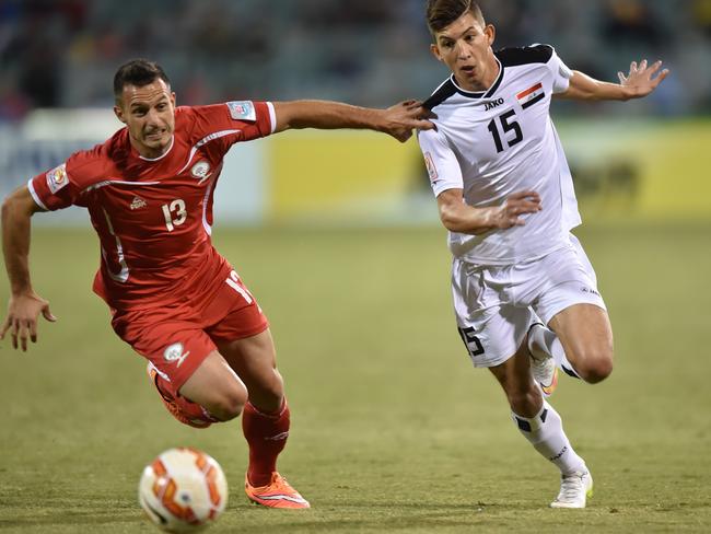 Dhurgham Ismail of Iraq (r) and Jaka Hbaisha of Palestine compete for the ball during their Asian Cup Group D match in Canberra.