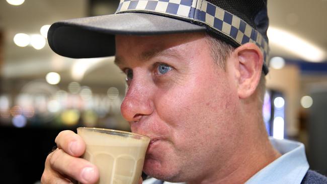 Senior Constable Matt Green samples his colleague’s work. (AAP Image / Angelo Velardo)