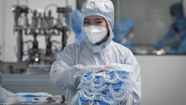 A worker packages up personal protective equipment in a factory in Beijing. Picture: AFP