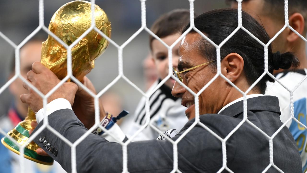 Nusret Goekce, nicknamed Salt Bae, admires the FIFA World Cup Qatar 2022 Winner's Trophy.