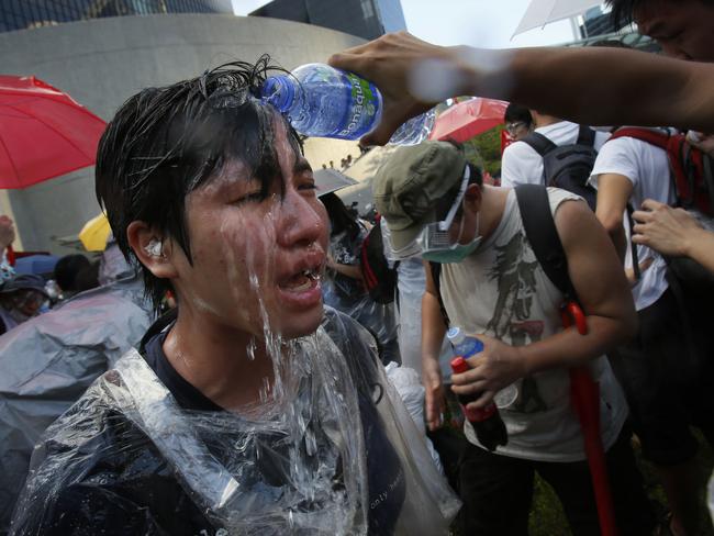 A student protester is overcome by pepper spray from riot police.