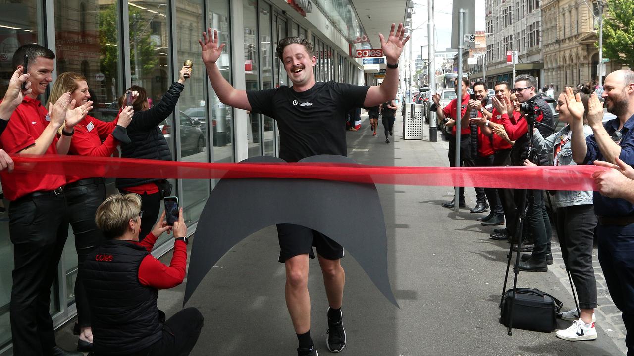 Coles Victorian city regional manager Ben Reeve reaches the finish line of his Movember marathon in Smith St, Collingwood. Picture: Hamish Blair