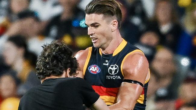 Ben Keays of the Crows knocks a pitch invader to the ground during the round two AFL match between Adelaide Crows and Geelong Cats. Picture: Mark Brake/Getty Images