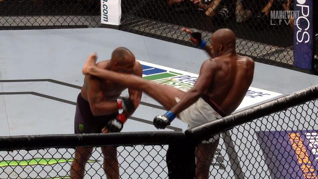 Jon Jones kicks Daniel Cormier in the head.