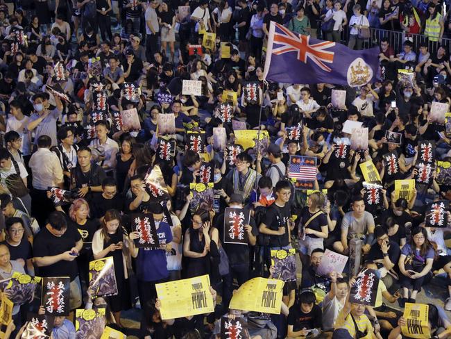 Pro-democracy protesters display placards and wave a colonial era flag of Hong Kong during a rally organised by higher education students in Chater Garden in Hong Kong. Picture: AP