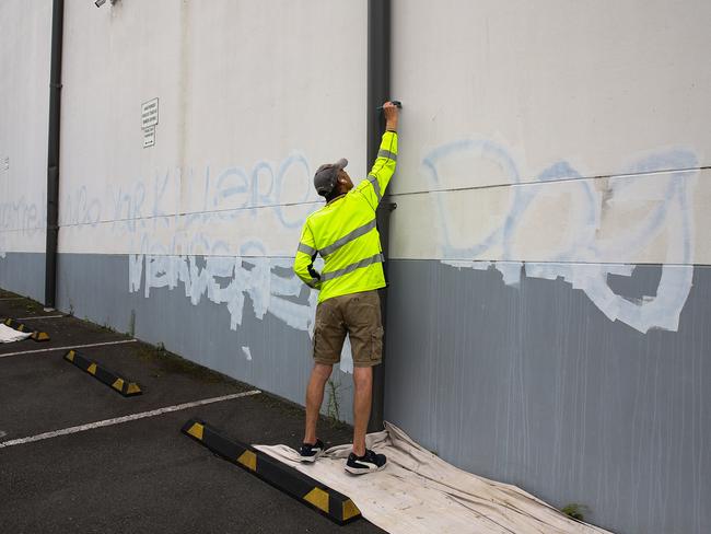 A council worker working to remove the graffiti on the wall of the carpark at the Mount Sinai College in Maroubra. Picture: NewsWire/ Gaye Gerard