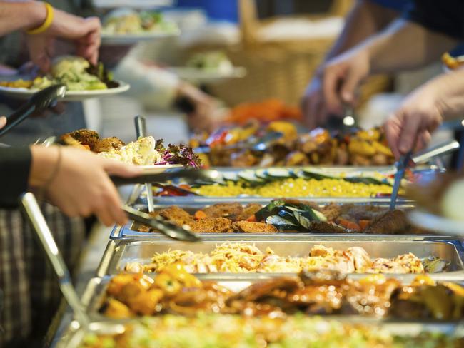 People taking food from a smorgasboard stock photo