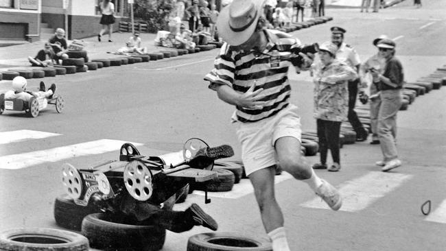 CRASH: Gympie Times photographer Tony Watson leaps out of the way as a entrant in Gympies annual Gold Rush Festival billy cart race crashes in Monkland St, near the Nash St intersection, after losing a tyre, in the early 1990s. Max Krogh took this amazing action picture of the instant of disaster, with the tyre that caused the crash still rolling along the road on the lower right side of the photograph and Mr Watson still in the air as he jumped out of the way. Picture: Renee Albrecht