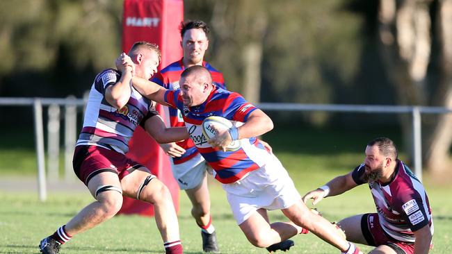 Pirates player Peter Woodward looks to shrug off a Nerang defender.