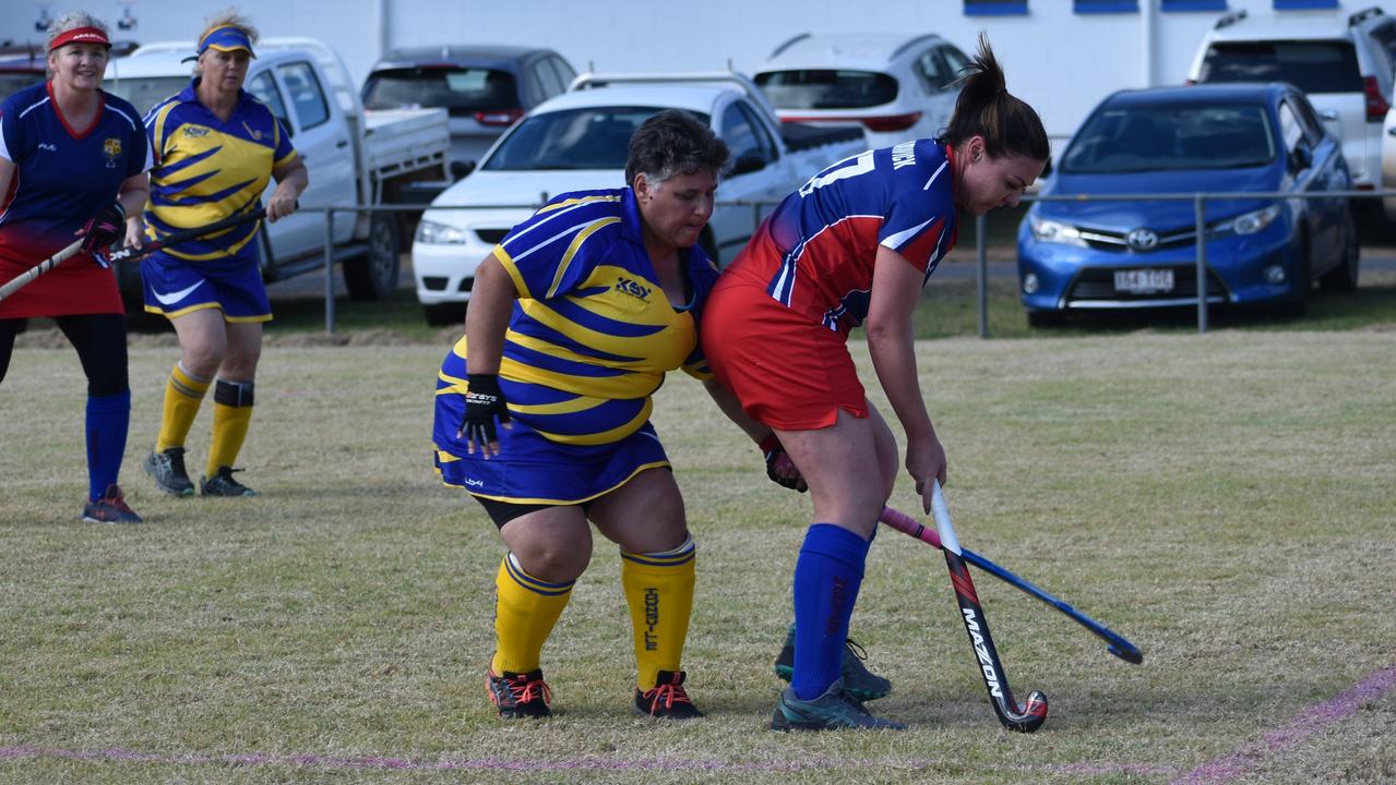 Danielle Cook (Warwick) and Lew Urquhart (Townsville) fight for possession in the big clash at the 2021 Queensland Hockey Women's Masters Championships.