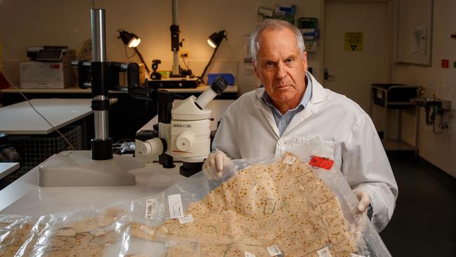 Professor Chris Pearman, retiring director of Forensic Science SA holding the pyjama top worn by Louise Bell when she was abducted in 1983. Picture Matt Turner.