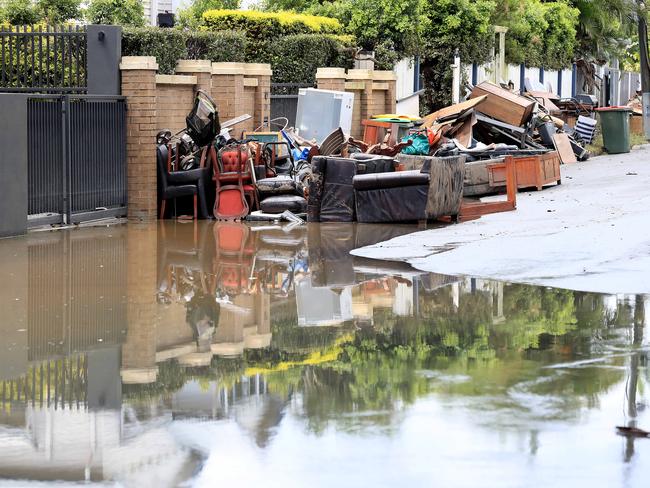 Residents of Fairfield continue the clean-up after floodwaters ravaged their homes and streets. Picture: Adam Head