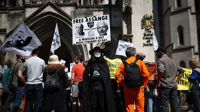 Pro-Assange protesters hold banners and placards outside The Royal Courts of Justice, in central London, on Monday. Picture: AFP