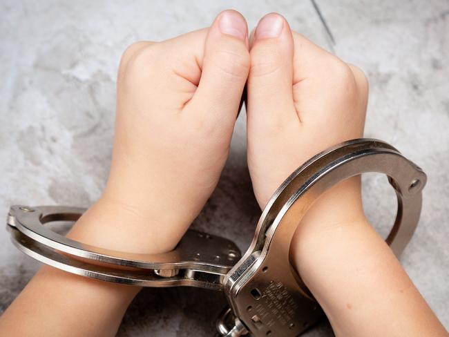 Picture of young child's hands in hand cuffs