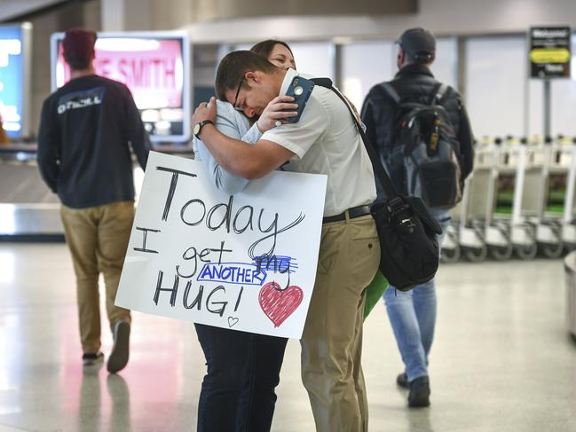 In this Tuesday, March 24, 2020 photo, after flying from Brazil, Gavin Wolcott, 19, gets a welcome home hug from his mother, Coralee, at Spokane International Airport, in Spokane, Wash. Wolcott was serving a mission in Brazil, but his stay in the country was cut short due to concerns over the coronavirus. (Dan Pelle/The Spokesman-Review via AP)