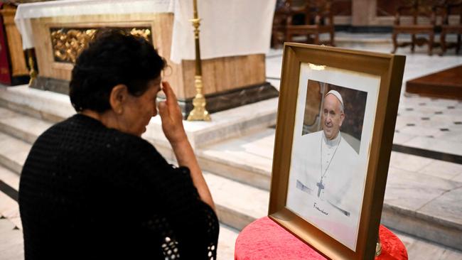 A woman crosses herself in front of a picture of Pope Francis during the celebration of Ash Wednesday. Picture: AFP