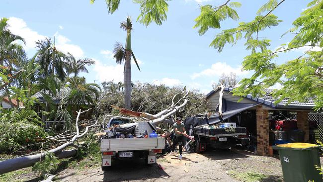 Damian Wheeler helps friends with the massive clean up as trees landed on their house in Helensvale. Pics Adam Head